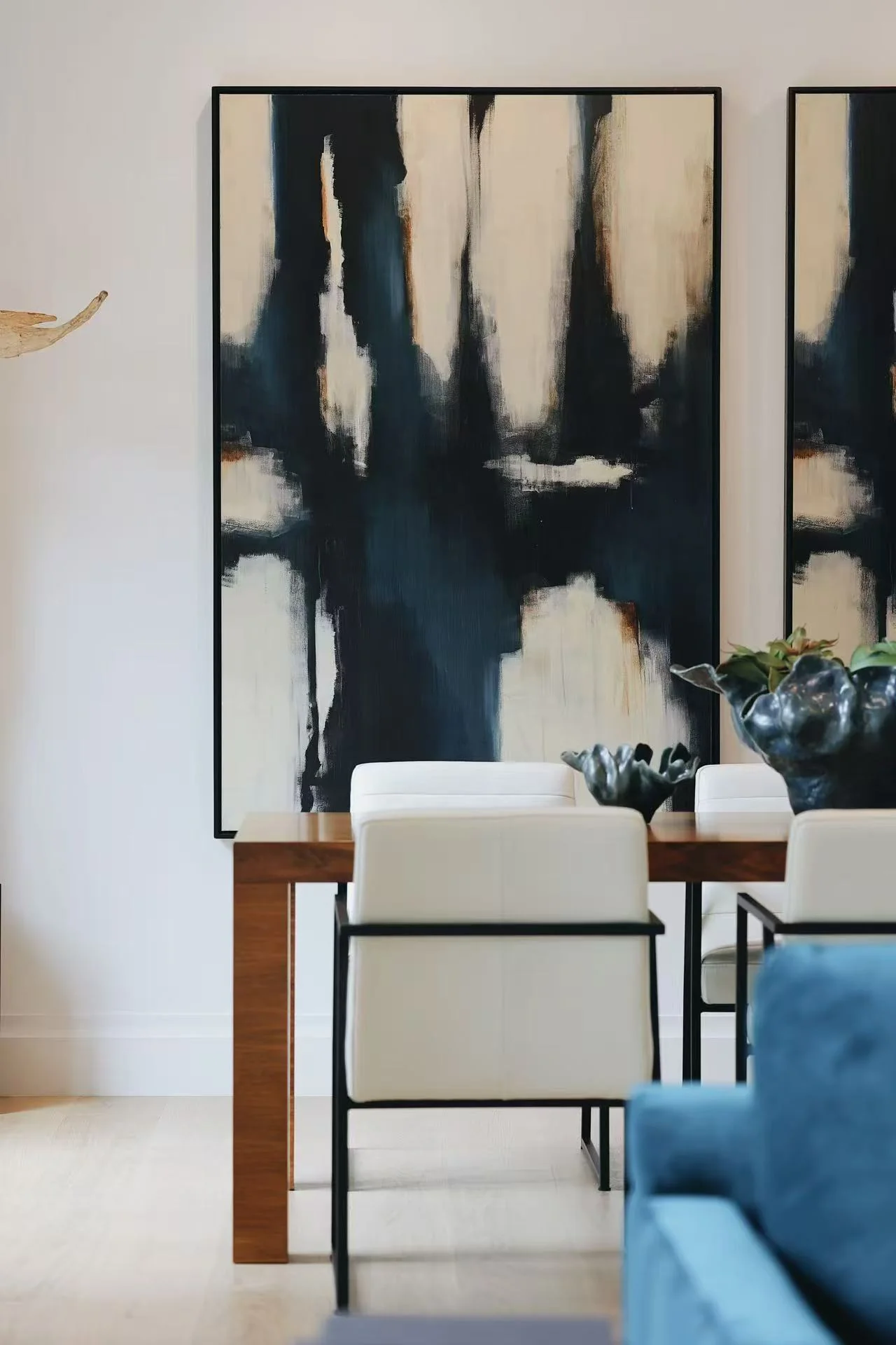 Abstract artwork, console table, and blue sofa detail