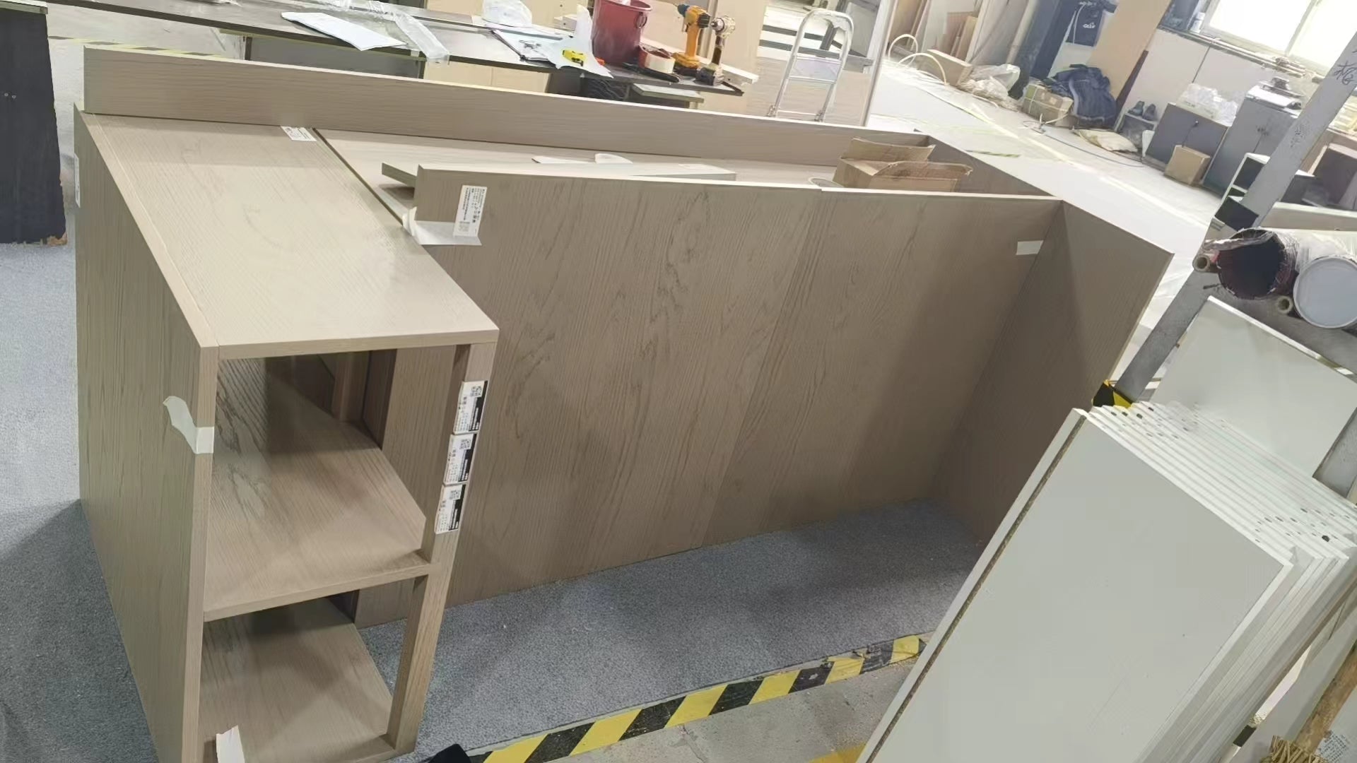 White oak island carcass assembled on the factory floor with open end shelving