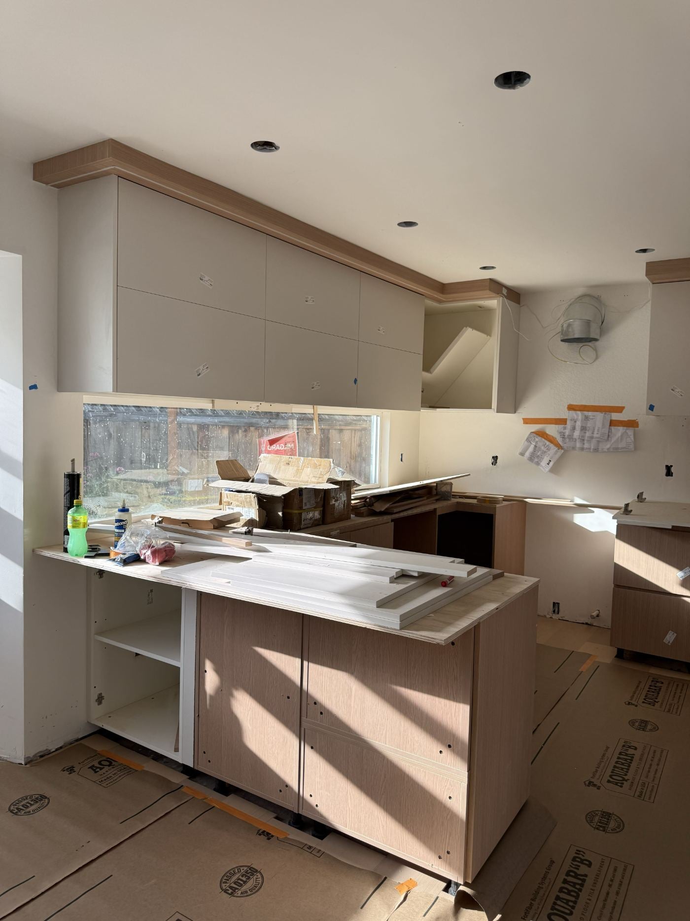 Peninsula base cabinets positioned with the window run behind