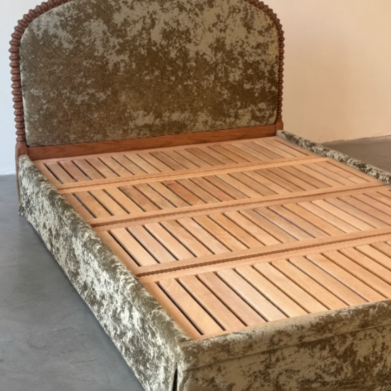 Upholstered bed frame with wooden slat structure inspected for alignment
