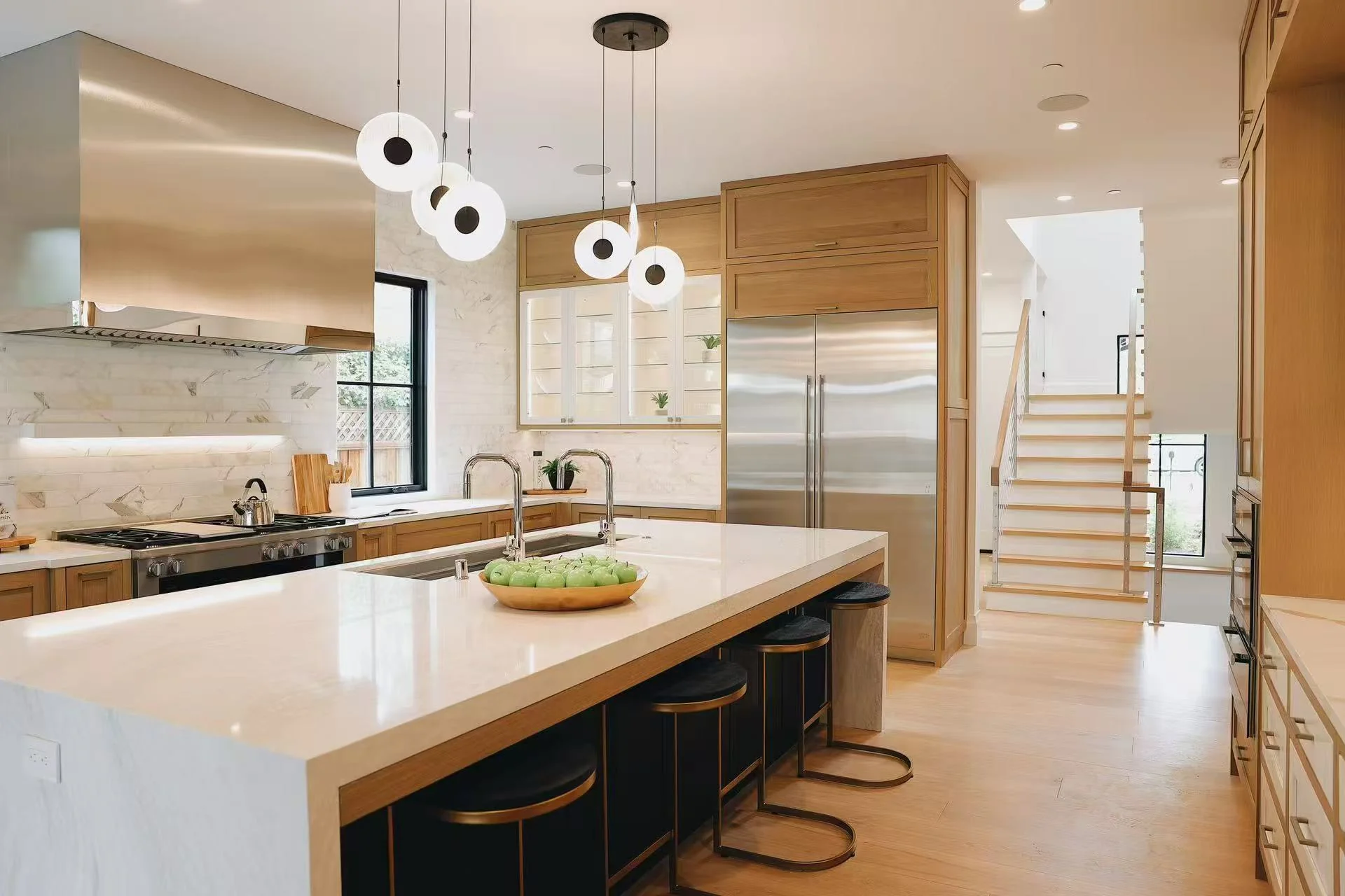 Wide view of the warm timber kitchen with central island, stainless steel appliances, and pendant lighting