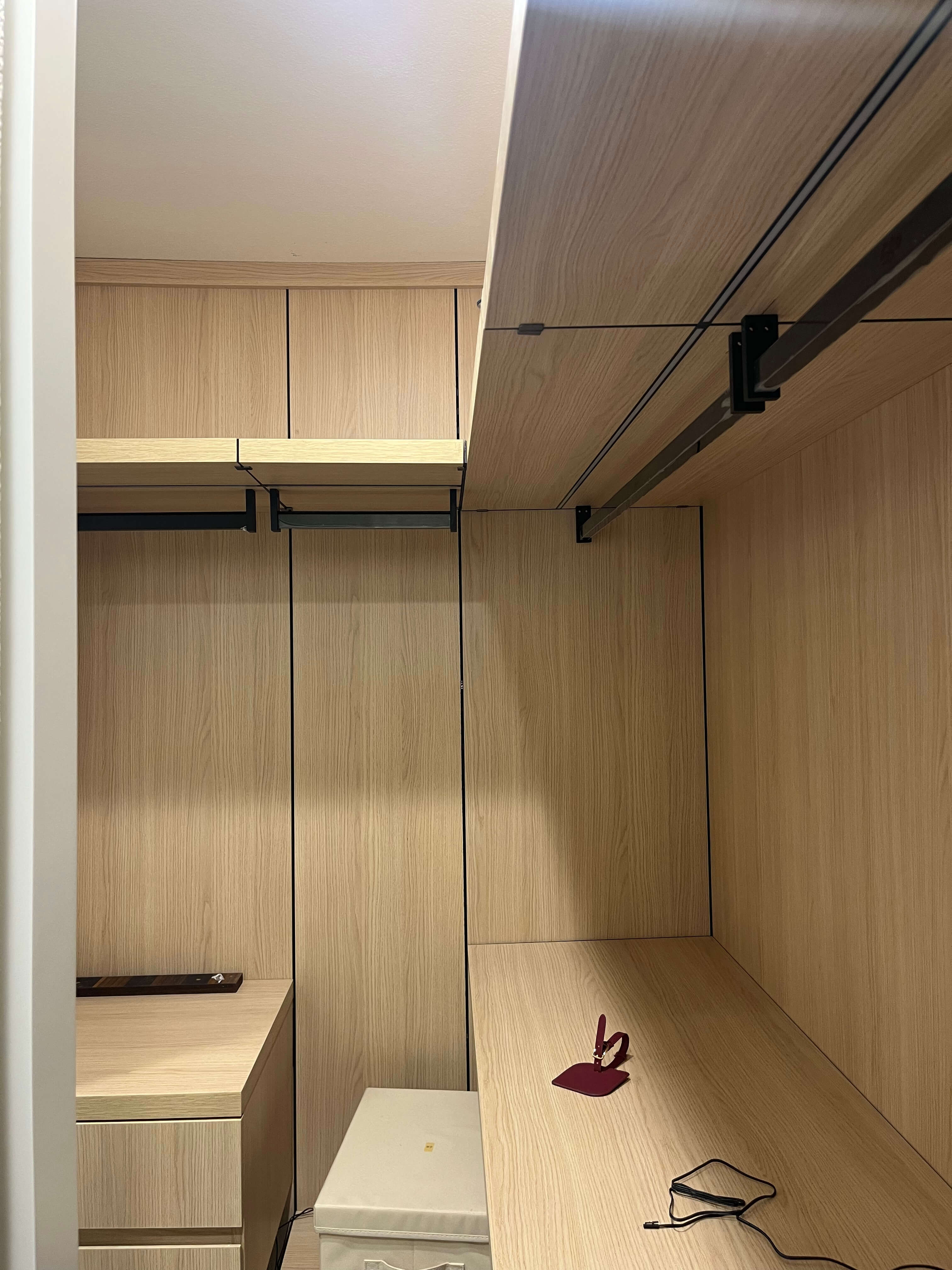 Walk-in closet in matching oak with black hanging rails and open shelving