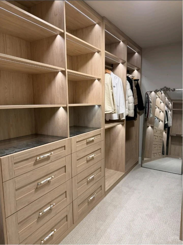 Completed Seattle walk-in closet with lit open shelving and hanging bays